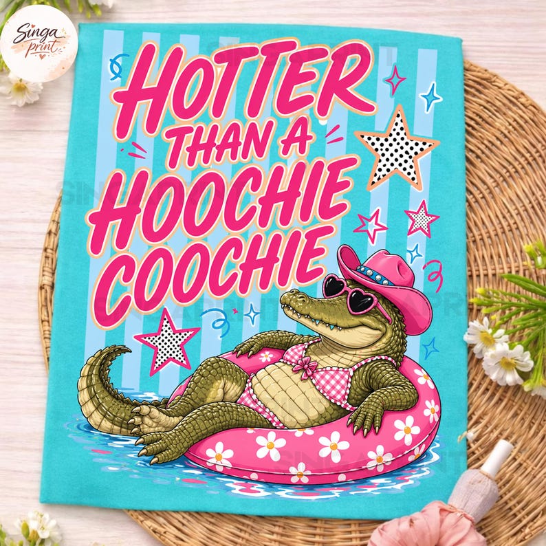 May include: A turquoise t-shirt with the text "Hotter Than a Hoochie Coochie" in pink. The shirt features an alligator wearing sunglasses, a pink cowboy hat, and a gingham bikini, floating on a pink inner tube with white flowers.