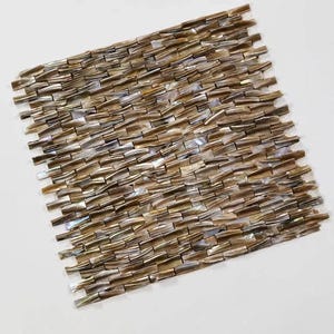 May include: A square mosaic tile sheet composed of small, rectangular pieces in shades of brown, gold, and silver. The tiles are arranged in a staggered pattern, creating a textured surface. The overall effect is a shimmering, natural look, suitable for home decor.