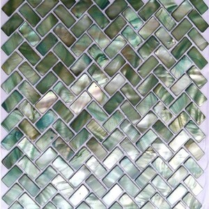 以下が含まれることがあります： ヘリンボーン模様の正方形モザイクタイルシート。長方形のタイルは、緑、白、青の色合いの真珠光沢仕上げです。タイルは対角線上に配置され、テクスチャのある表面を作り出しています。