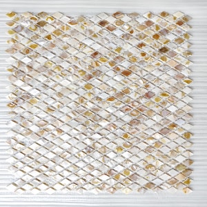 以下が含まれることがあります： 小さなひし形のタイルで構成された正方形のモザイクタイルシート。タイルは、白からタン、茶色まで、真珠のような光沢があります。タイルは格子状に配置され、テクスチャード加工された表面を作り出しています。