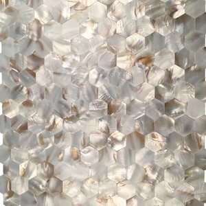 以下が含まれることがあります： モザイクタイルのパターンのクローズアップ。タイルは六角形で、白、クリーム、茶色の色合いの真珠光沢のある虹色の仕上げが施されています。タイルは格子状に配置され、テクスチャのある表面を作り出しています。