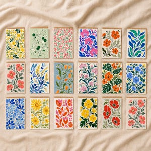 May include: A collection of eighteen rectangular greeting cards arranged in three rows, each featuring a unique botanical illustration with vibrant floral patterns, including various flowers, leaves, and vines in diverse colour palettes.
