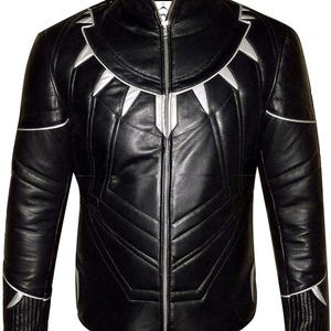 Puede incluir: Chaqueta de cuero negra con detalles plateados. La chaqueta presenta un cuello alto, una cremallera completa y diseños geométricos plateados en el pecho, los hombros y las mangas. La chaqueta tiene un patrón acolchado.