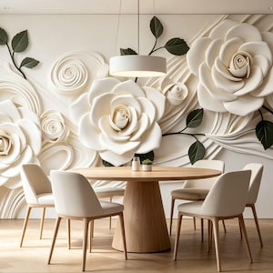 May include: A dining room featuring a round light wood table with four off-white chairs. The wall behind the table displays a large, three-dimensional relief mural of cream-colored roses with dark green leaves and swirling, abstract white lines.