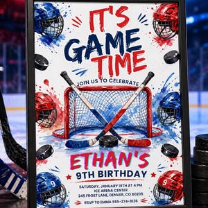 May include: A framed hockey-themed birthday party invitation. The design features a hockey net, crossed hockey sticks, pucks, and helmets in red and blue. Text reads "It's Game Time" and "Ethan's 9th Birthday".
