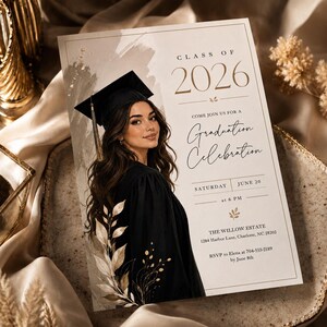 May include: Graduation announcement card featuring a portrait of a person in a graduation gown and cap. The card has the text "Class of 2026" and "Graduation Celebration". The card's design includes floral elements and event details.