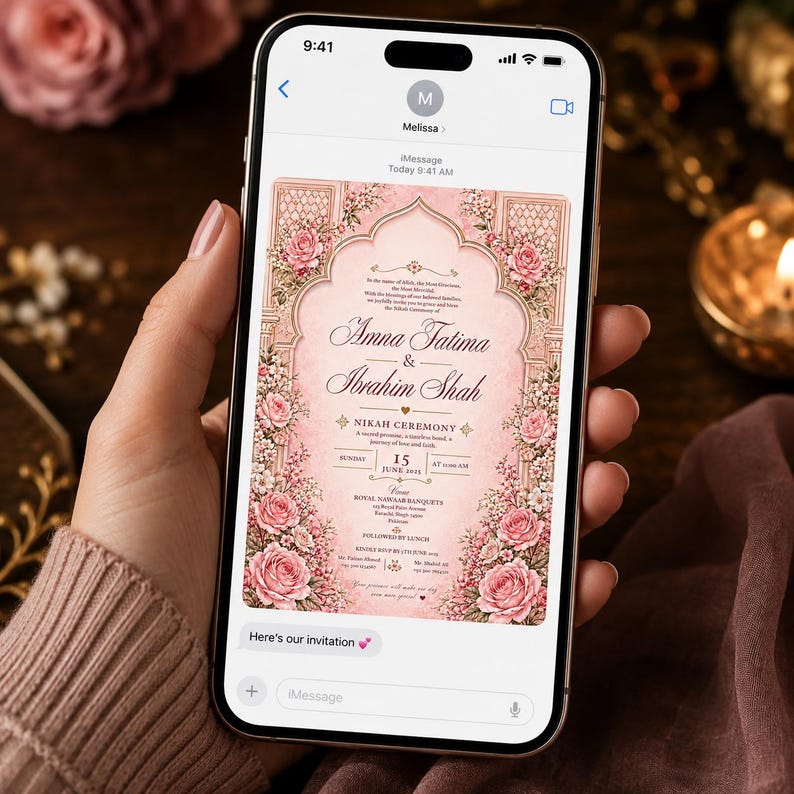 May include: A smartphone displaying a digital wedding invitation for Amna Fatima and Ibrahim Shah. The invitation features a pink background with an ornate archway, floral borders of pink roses, and text detailing a Nikah ceremony on June 15, 2025.
