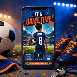 May include: A smartphone displays a soccer-themed birthday invitation with the text "IT'S GAME TIME!" and details for Logan's 8th birthday. The design features a soccer player, a soccer ball, and blue and orange accents. A soccer ball, cleats, and a whistle are also visible.