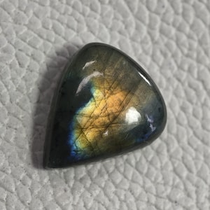 May include: A white ceramic mug with a black handle and the text "But First, Coffee" in a bold, black font. The mug is set against a blurred background, suggesting a cozy setting.