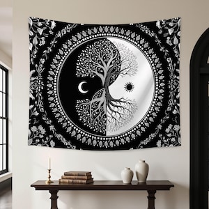 Może przedstawiać: Czarno-biały gobelin z motywem Yin i Yang z drzewem życia. Projekt zawiera półksiężyc i słońce, otoczone kwiatową obwódką. Gobelin wisi na białej ścianie.