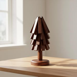 May include: A wooden decorative tree with a dark brown finish. The tree is constructed from multiple layered wooden pieces, creating a textured, layered effect. It stands on a round base and a cylindrical trunk, perfect for home decor.