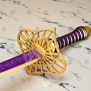 May include: A decorative sword with a gold-colored guard and a purple blade. The handle is wrapped in purple fabric. The sword has intricate details and a unique design.