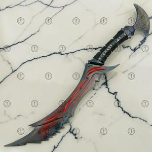 May include: A fantasy dagger with a curved blade and a detailed handle. The blade is primarily gray with red accents, and the handle is black with silver detailing. The dagger has a unique, stylized design.