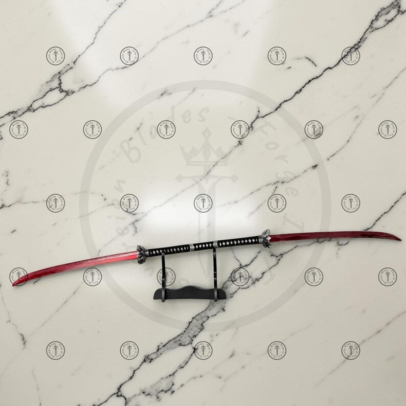 May include: A double-edged sword with a red blade and black handle, displayed on a black stand. The blade has a curved design, and the handle is detailed with silver accents. The sword is set against a white marble background.