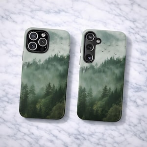 May include: Two phone cases with a forest scene design. The cases feature a misty green forest with tall trees and flying birds. The cases have black camera and button details and are set against a marble background.