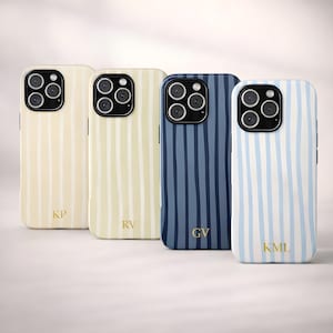 May include: Four phone cases with vertical stripe designs in cream, light yellow, navy blue, and light blue. Each case has a different gold monogram: KP, RV, GV, and KML. The cases have a glossy finish and are designed for a smartphone.