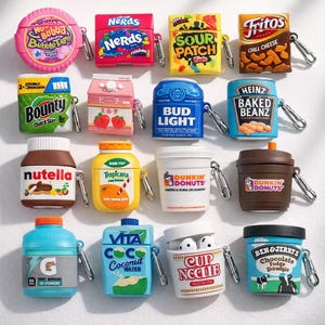 May include: A selection of novelty AirPod cases designed to resemble popular food and drink products. The cases feature brands like Fritos, Heinz Baked Beanz, and Ben & Jerry's ice cream. Each case has a silver clip for attaching to a bag or keyring.