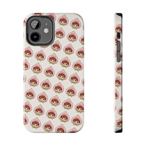 May include: A white phone case featuring a repeating pattern of cartoon characters inside pink peach shapes. The case has a black camera cutout and black side buttons. The design is repeated on the side of the case.