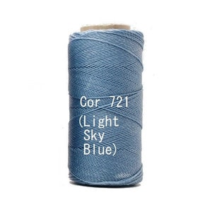 May include: A spool of light sky blue thread, labelled "Cor 721 (Light Sky Blue)". The thread is tightly wound, showing a textured surface. The spool is set against a white background.