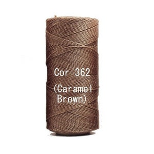 May include: A spool of caramel brown thread, labelled "Cor 362 (Caramel Brown)". The thread is tightly wound, showing a textured surface. The background is plain white.