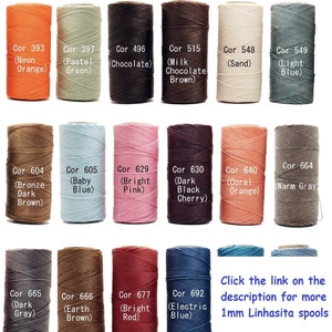 May include: A collection of 1mm waxed linen thread spools in various colors, including neon orange, pastel green, chocolate brown, milk chocolate brown, sand, light blue, bronze dark brown, baby blue, bright pink, dark black cherry, coral orange, warm gray, dark gray, earth brown, bright red, and electric blue. The spools are labeled with their color names and corresponding numbers.
