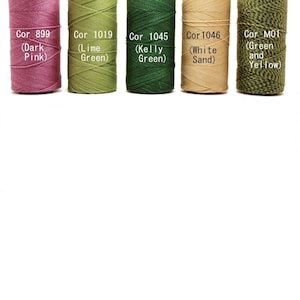 May include: Five spools of embroidery thread in different colors. The colors are dark pink, lime green, kelly green, white sand, and green and yellow.