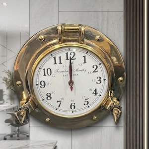 Reloj de pared náutico de latón con ojo de buey de 23 cm, estilo ventana de barco marítimo, decoración costera.
