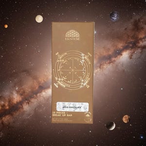Könnte beinhalten: Eine rechteckige Milchschokoladentafel in brauner Verpackung mit einem kreisförmigen astrologischen Diagramm, dem Markennamen EKSTESE und dem Text 15 PIECES - BREAK UP BAR, NET WT 1.77 OZ (50G). Das Design enthält die Bezeichnungen Earth, Air, Water und Fire.