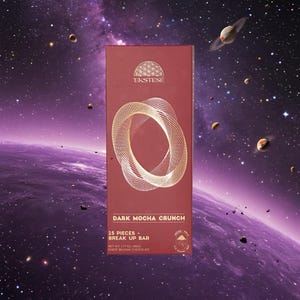 Puede incluir: Una tableta de chocolate rectangular de color rojo oscuro etiquetada como EKSTESE DARK MOCHA CRUNCH. El frente presenta un diseño circular geométrico dorado, el texto 15 PIECES - BREAK UP BAR y NET WT 1.77OZ (50G) FINEST BELGIAN CHOCOLATE abajo.