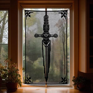 May include: Black decorative window curtain featuring a detailed sword design. The curtain is made of a mesh material and is framed by a wooden window. The sword design is centered and has intricate details. Decorative accents are in each corner.