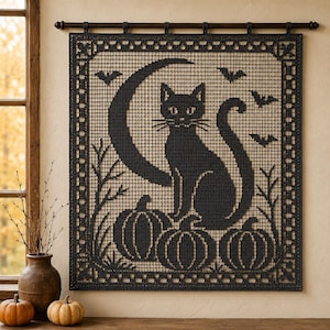 May include: A black crochet wall hanging featuring a central cat silhouette sitting in front of a large crescent moon. The design includes three pumpkins at the base, several flying bats in the upper corners, and a decorative border pattern.
