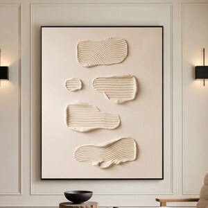 May include: A modern living room with a large abstract art piece. The artwork features textured, cream-colored shapes on a neutral background. A glass coffee table, a wooden chair, and a light-colored rug complete the space.