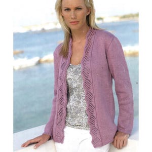 May include: A long-sleeved, open-front cardigan in a solid mauve color. The garment features a decorative, vertical open-knit lace pattern along the front edges and neckline, paired with a silver sequined top and white trousers underneath.