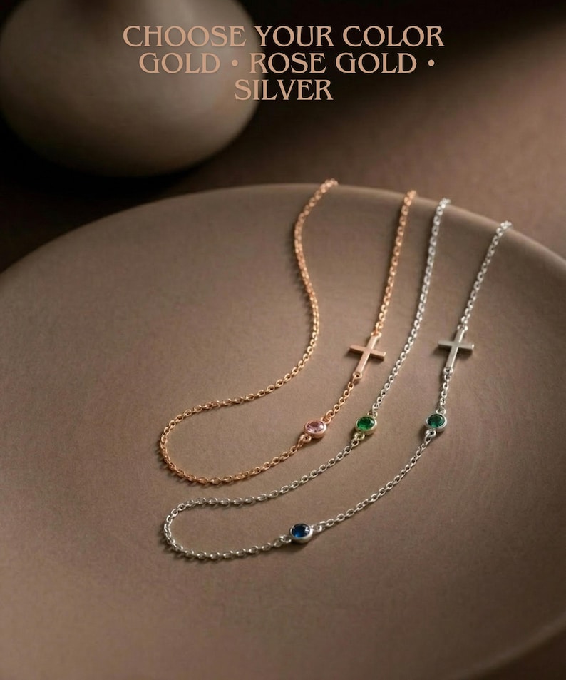Puede incluir: Tres delicados collares con colgantes de cruz y detalles de piedras preciosas en oro, oro rosa y plata. Cada collar presenta una peque&ntilde;a gema rosa, verde o azul. El texto dice: "CHOOSE YOUR COLOR GOLD &bull; ROSE GOLD &bull; SILVER."