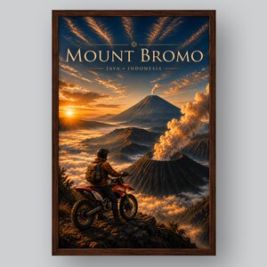Puede incluir: Un póster de viaje enmarcado que muestra a un motociclista observando el monte Bromo en Java, Indonesia. La escena presenta un volcán humeante al amanecer con luz dorada, nubes y un marco de madera oscura que rodea la impresión vertical.