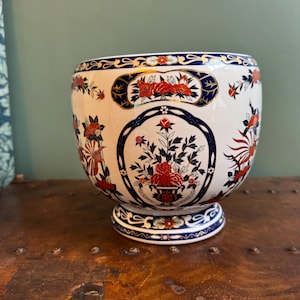 May include: A white ceramic mug with a black handle and the text "But First, Coffee" in a handwritten style. The mug is on a white surface. The mug is approximately 4 inches tall.