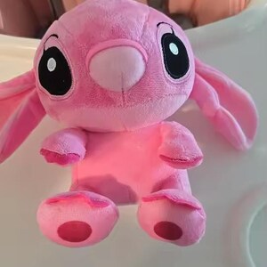Puede incluir: Un peluche rosa con grandes ojos negros, orejas largas y una nariz peque&ntilde;a. El juguete tiene un cuerpo redondo, brazos peque&ntilde;os y pies. El peluche es un personaje de una popular pel&iacute;cula de animaci&oacute;n.