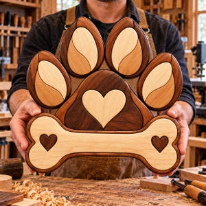 May include: A wooden wall art piece shaped like a paw print with a bone at the base. The design features contrasting dark walnut and light maple wood tones, with a central heart cutout in the paw and two smaller hearts on the bone ends.