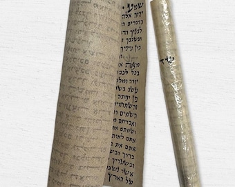 May include: Two rolled scrolls with Hebrew text. One scroll is partially unrolled, revealing columns of script. The other is tightly rolled and wrapped. The paper has a beige hue, and the text is in black.