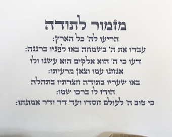May include: A white wall art print featuring Hebrew text in a dark gray font. The text is arranged in a vertical format, with multiple lines of script. The print has a minimalist design, suitable for home decor.