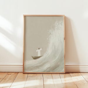Pode incluir: Uma impressão de arte emoldurada retrata uma pessoa com uma túnica branca em um pequeno barco, enfrentando uma grande onda. A obra de arte é em tons suaves de bege e branco, com uma moldura de madeira.