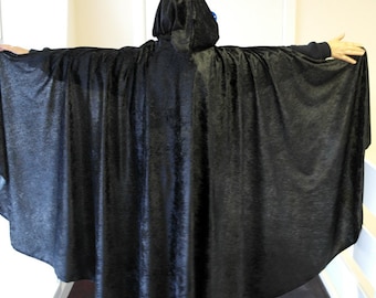 May include: A black velvet hooded cape with a long flowing design.