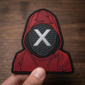 May include: A red and black patch featuring a hooded figure with a silver "X" on the face. The patch has a black border and a honeycomb pattern on the face. The figure is wearing a red hood.