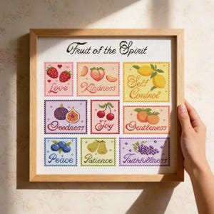 May include: A framed cross-stitch artwork featuring the words "Fruit of the Spirit." The artwork displays nine squares, each with a fruit illustration and a corresponding word: Love, Kindness, Self Control, Goodness, Joy, Gentleness, Peace, Patience, and Faithfulness.