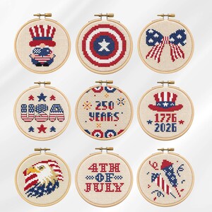 Pode incluir: Nove desenhos de ponto cruz em bastidores de madeira, com temas patrióticos. Os desenhos incluem um gnomo, um escudo, um laço, o texto "USA", o texto "250 Years", um chapéu com o texto "1776-2026", uma águia, o texto "4th of July" e um fogo de artifício.