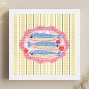 May include: Cross-stitch art in a white frame. The artwork features three blue fish on a yellow and pink plate, with red strawberries. The background has vertical yellow and white stripes. A decorative piece for a kitchen or dining room.