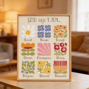 Puede incluir: Un muestrario de punto de cruz enmarcado sobre tela clara con el texto "GOD says I AM..." sobre nueve motivos florales. Cada flor está emparejada con una palabra: Loved, Known, Enough, Chosen, Courageous, Strong, Forgiven, Blessed y Treasured.