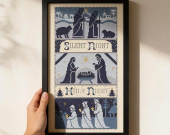 以下が含まれることがあります： クリーム色の背景にネイビーブルーとライトブルーの色合いで描かれた、キリスト降誕シーンのクロスステッチ刺繍。Silent NightとHoly Nightの文字が含まれ、人物、動物、星がグリッド状に配置されたデザインの額入り作品。