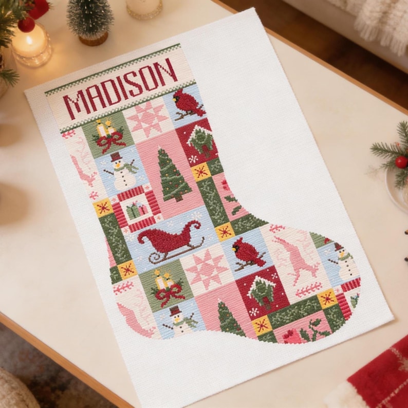 以下が含まれることがあります： 上部に「MADISON」という名前が入ったクリスマスストッキング。ストッキングは、雪だるま、木、そりなどのお祝いのイメージが、赤、緑、ピンク、青の色合いでパッチワークデザインになっています。ストッキングは白い表面にあります。