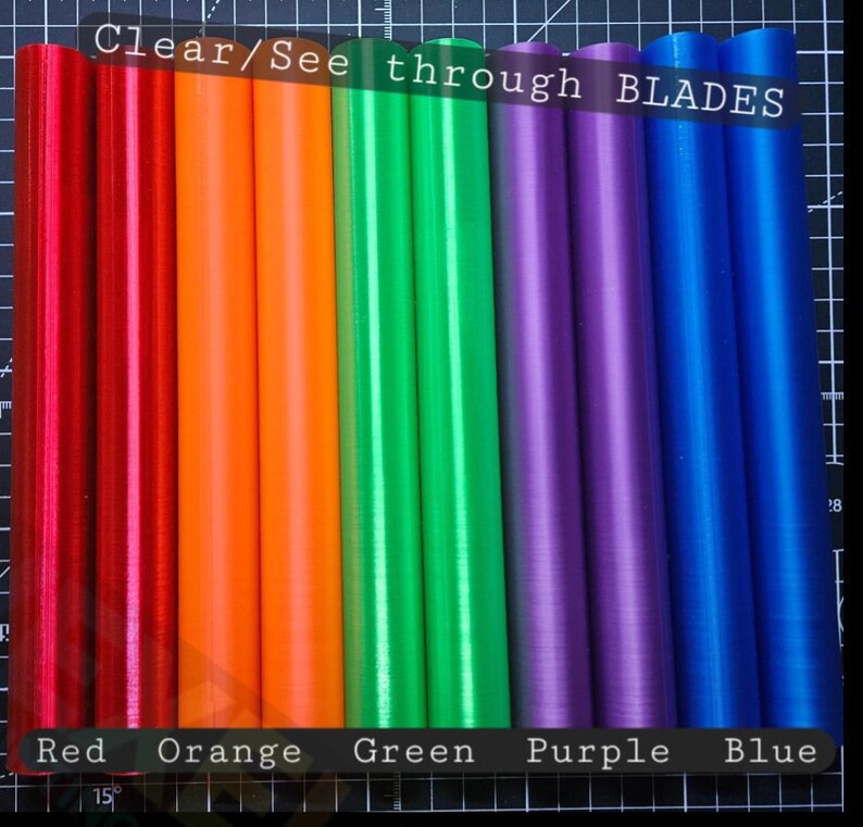 May include: A set of ten cylindrical blades arranged in a row, featuring a translucent finish in red, orange, green, purple, and blue. The text "Clear/See through BLADES" is visible at the top, with colour labels at the bottom.